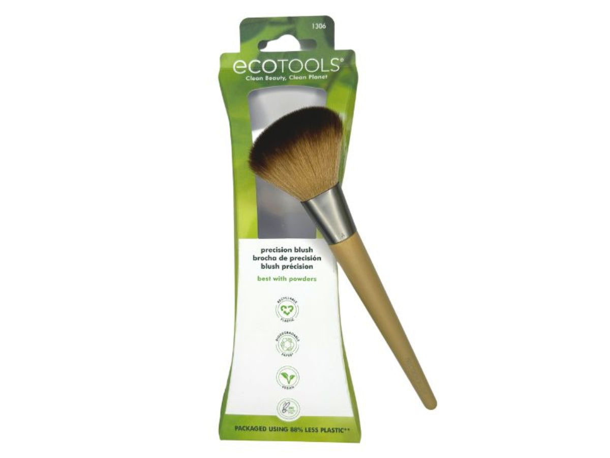 Blush brush sitting on top of its packaging on a white background