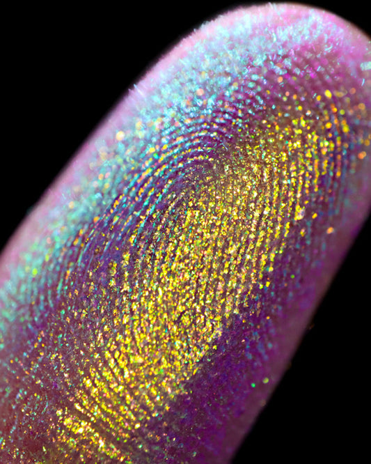 Close-up of a colorful glittery finger on a black background