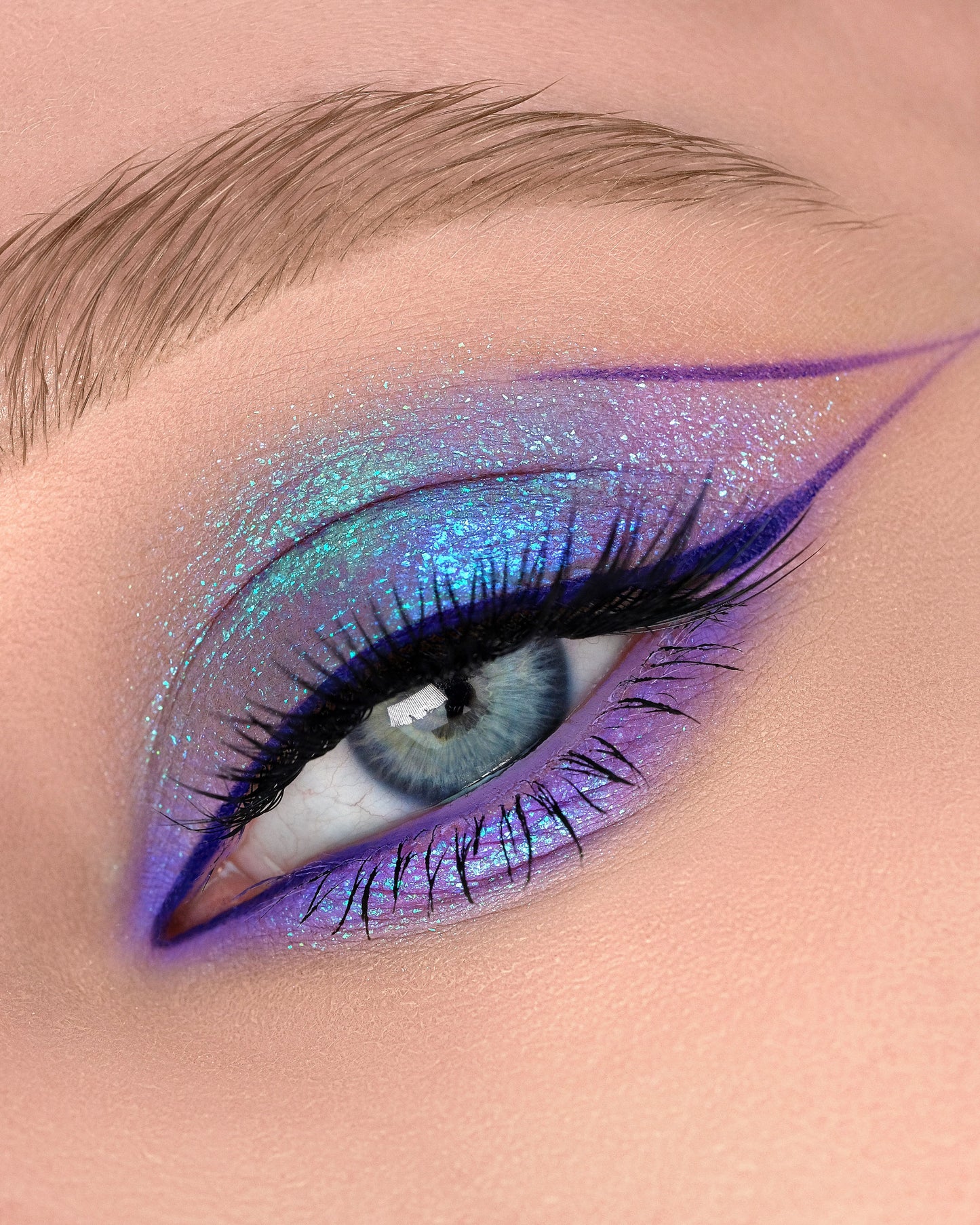 Close-up of a blue eye with purple and pink makeup using Dreamer gel