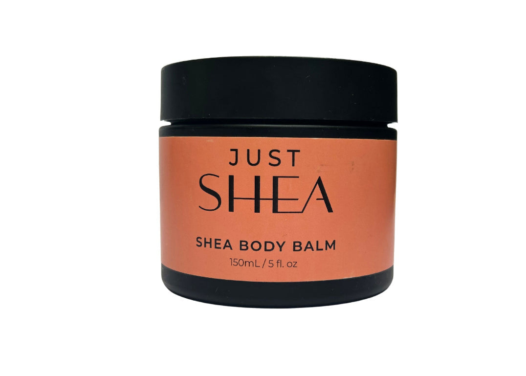 A jar of Just Shea Body Balm with a black lid and orange label, set against a white background.
