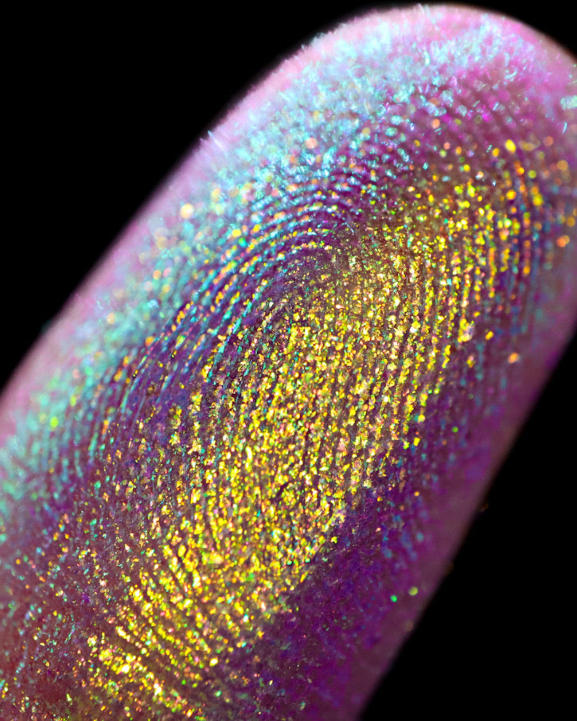 Close-up of a colorful glittery finger on a black background