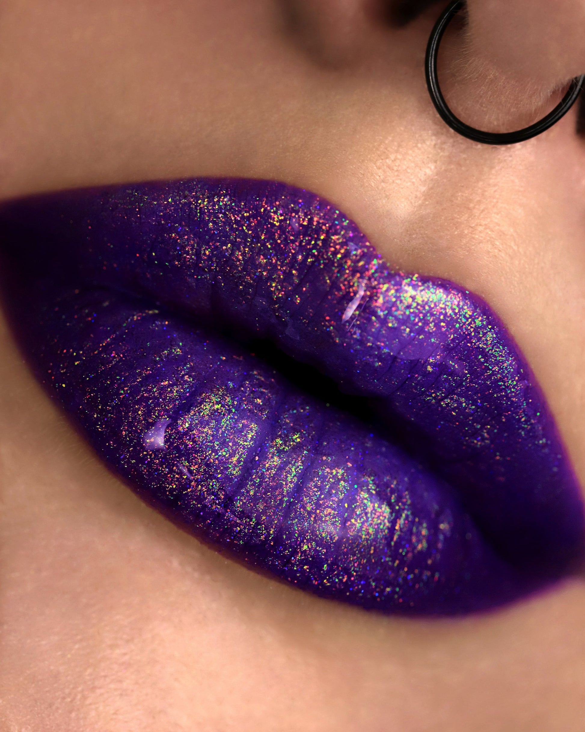 Close-up of a person wearing purple glittery lipstick.