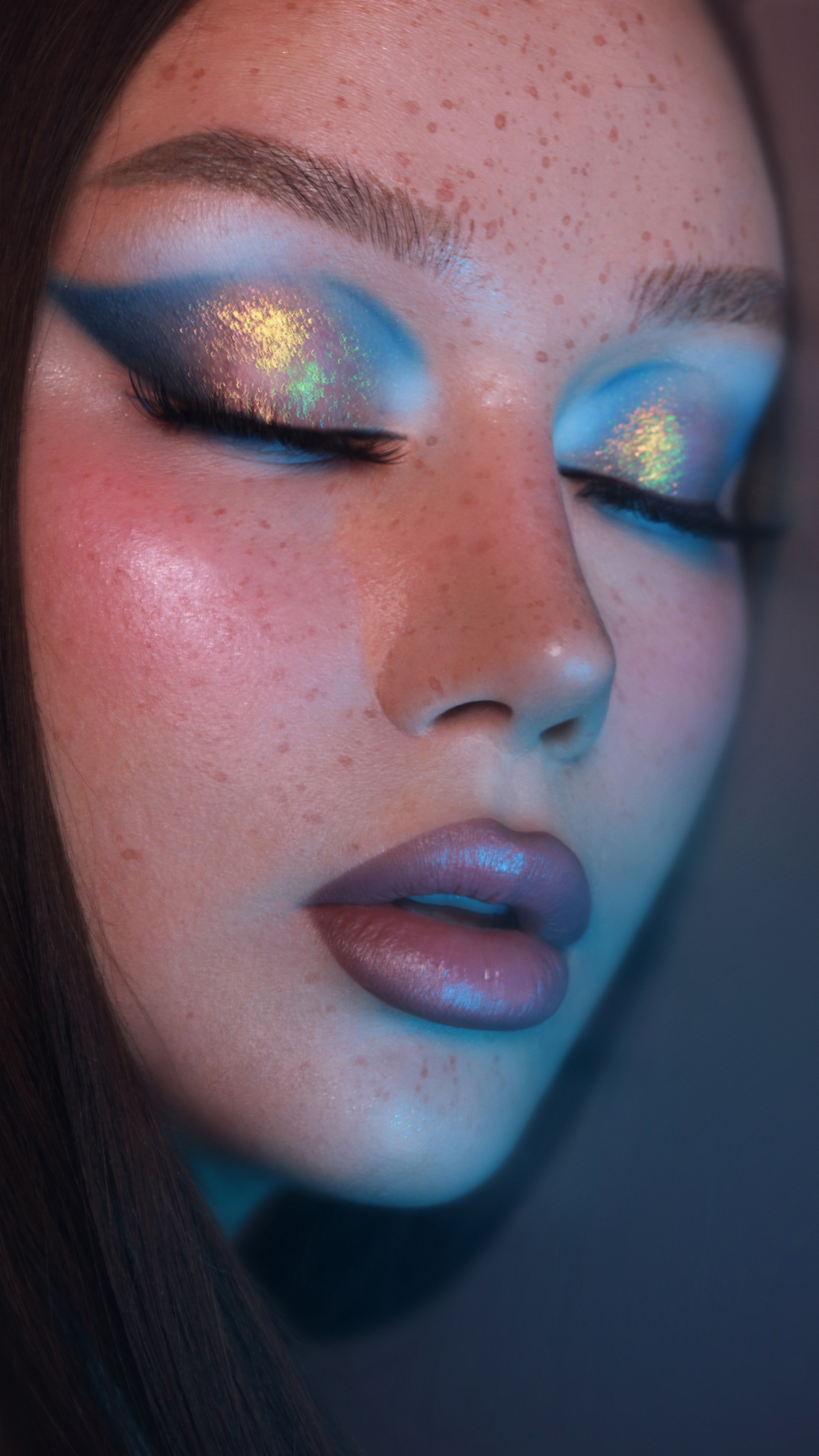 Close-up of a person with artistic eye makeup and a blurred background