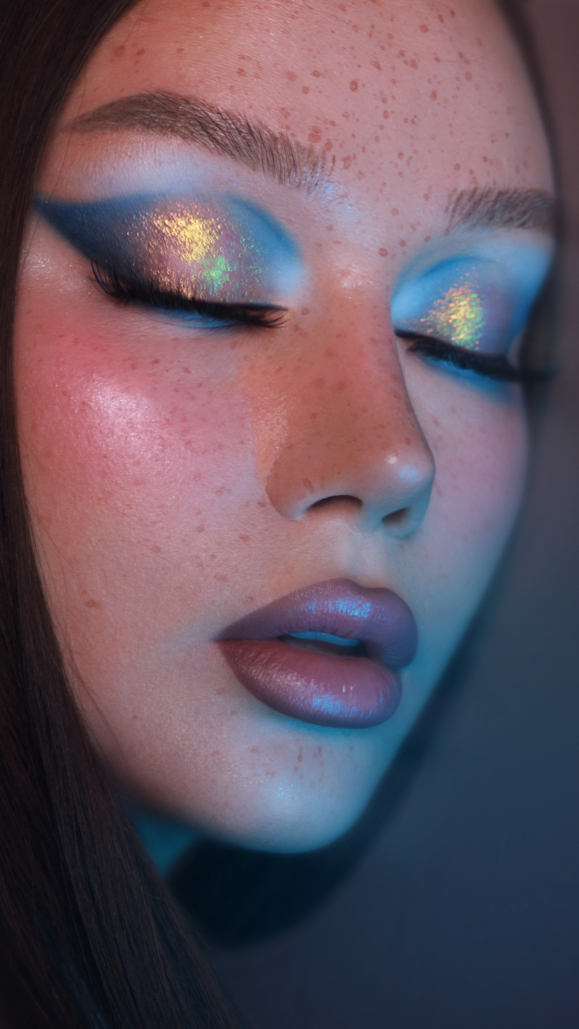 Close-up of a person with artistic eye makeup and a blurred background