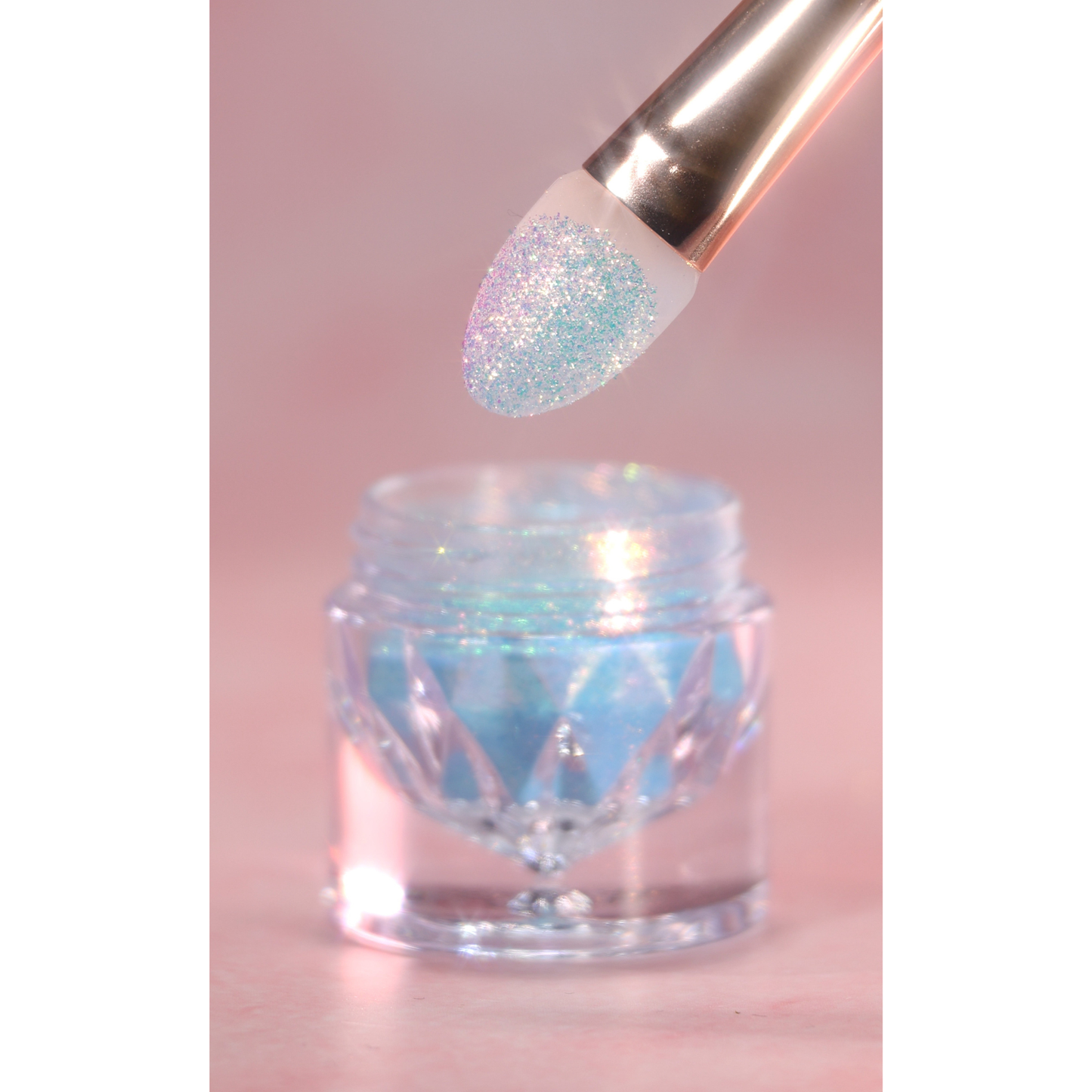 Glittery makeup brush dipping into a jar of glitter on a pink background