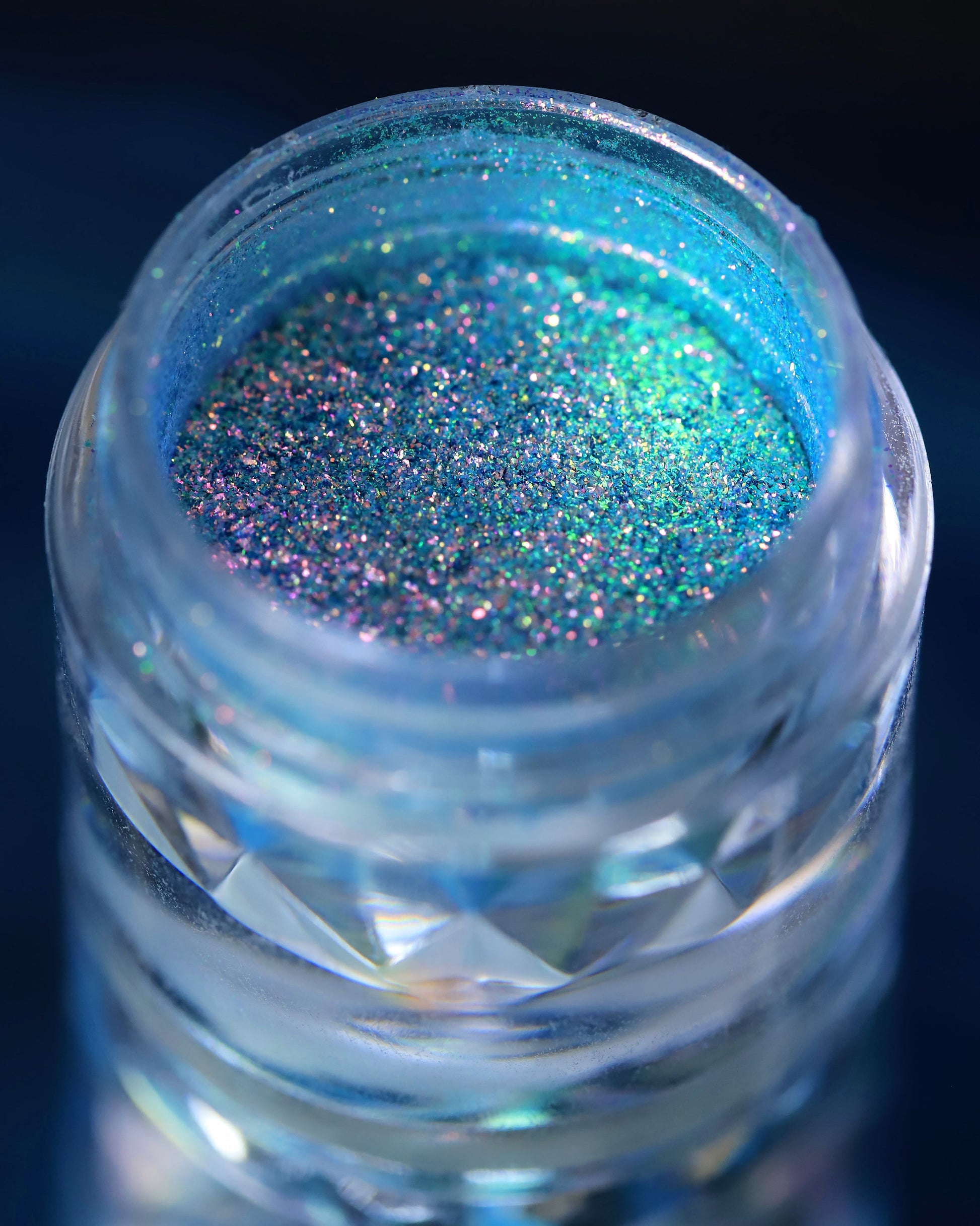 Jar of blue glitter on a dark background