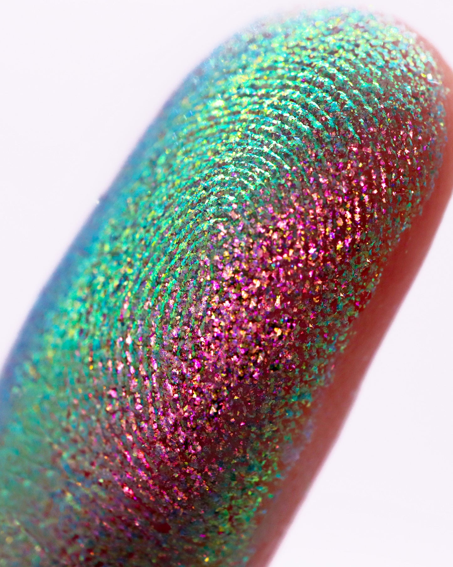 Close-up of a multicolored glittery finger on a white background