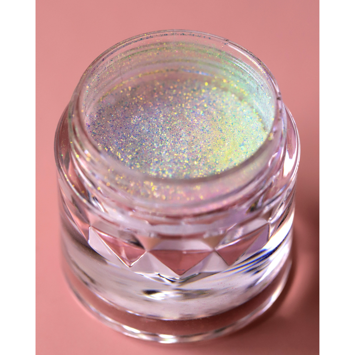 Jar of glittery powder on a pink background
