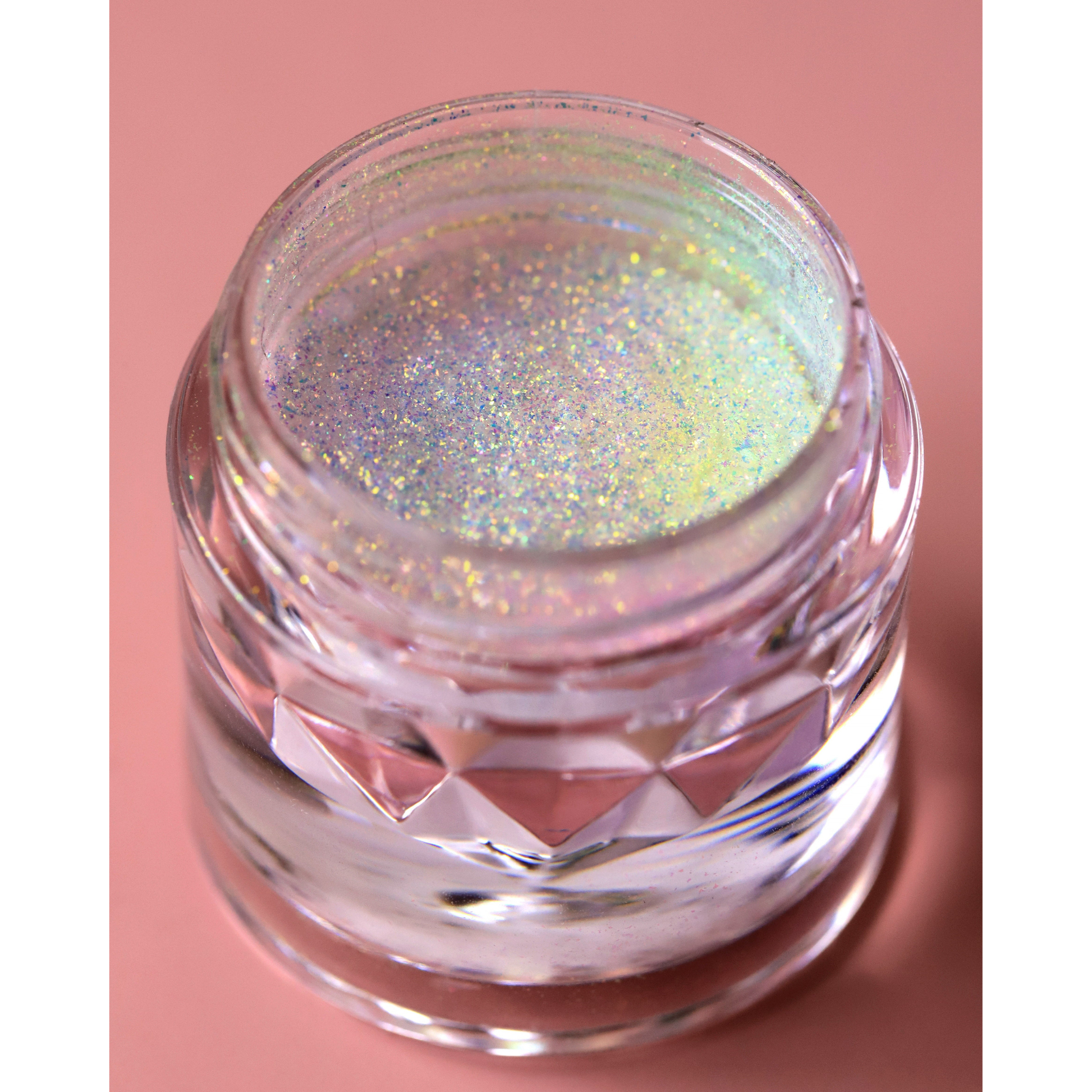 Jar of glittery powder on a pink background