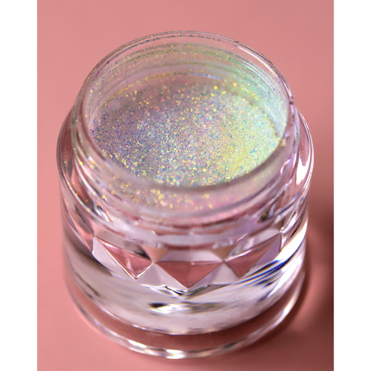 Jar of glittery powder on a pink background