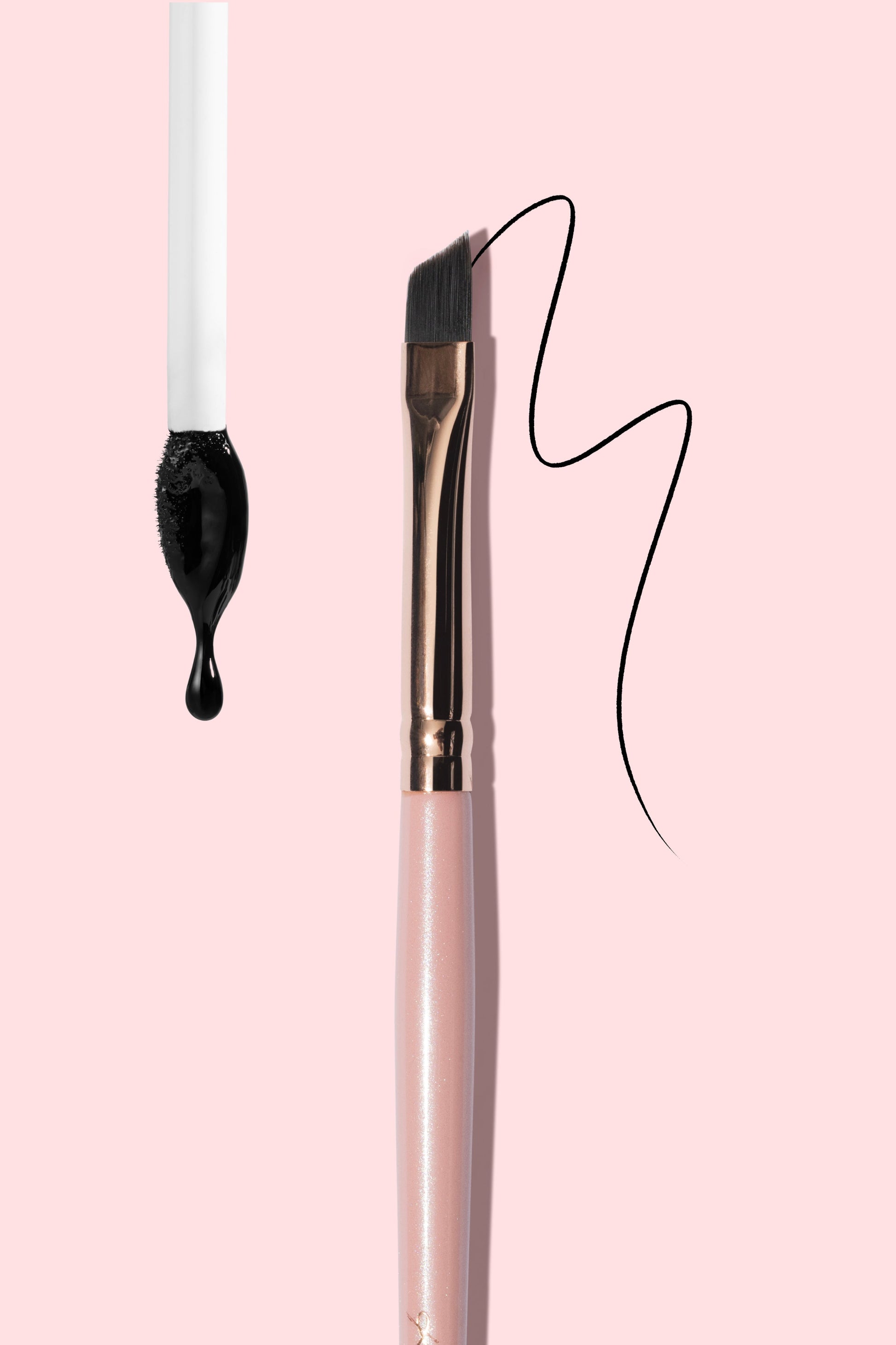Makeup brush with black liquid droplet and wavy line on pink background