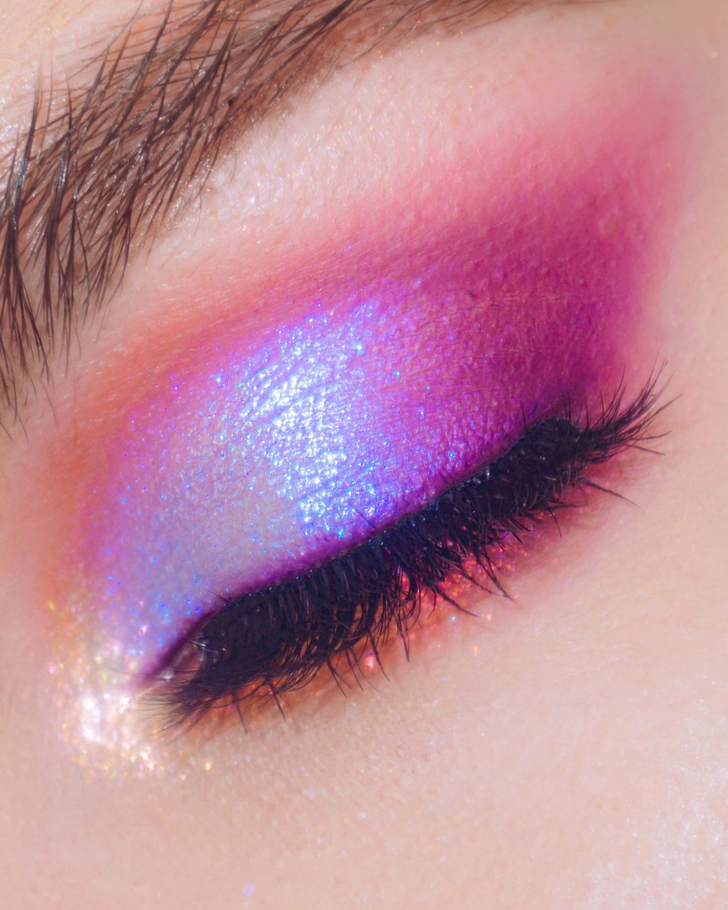 Close-up of a colorful eye makeup with purple and pink shades.