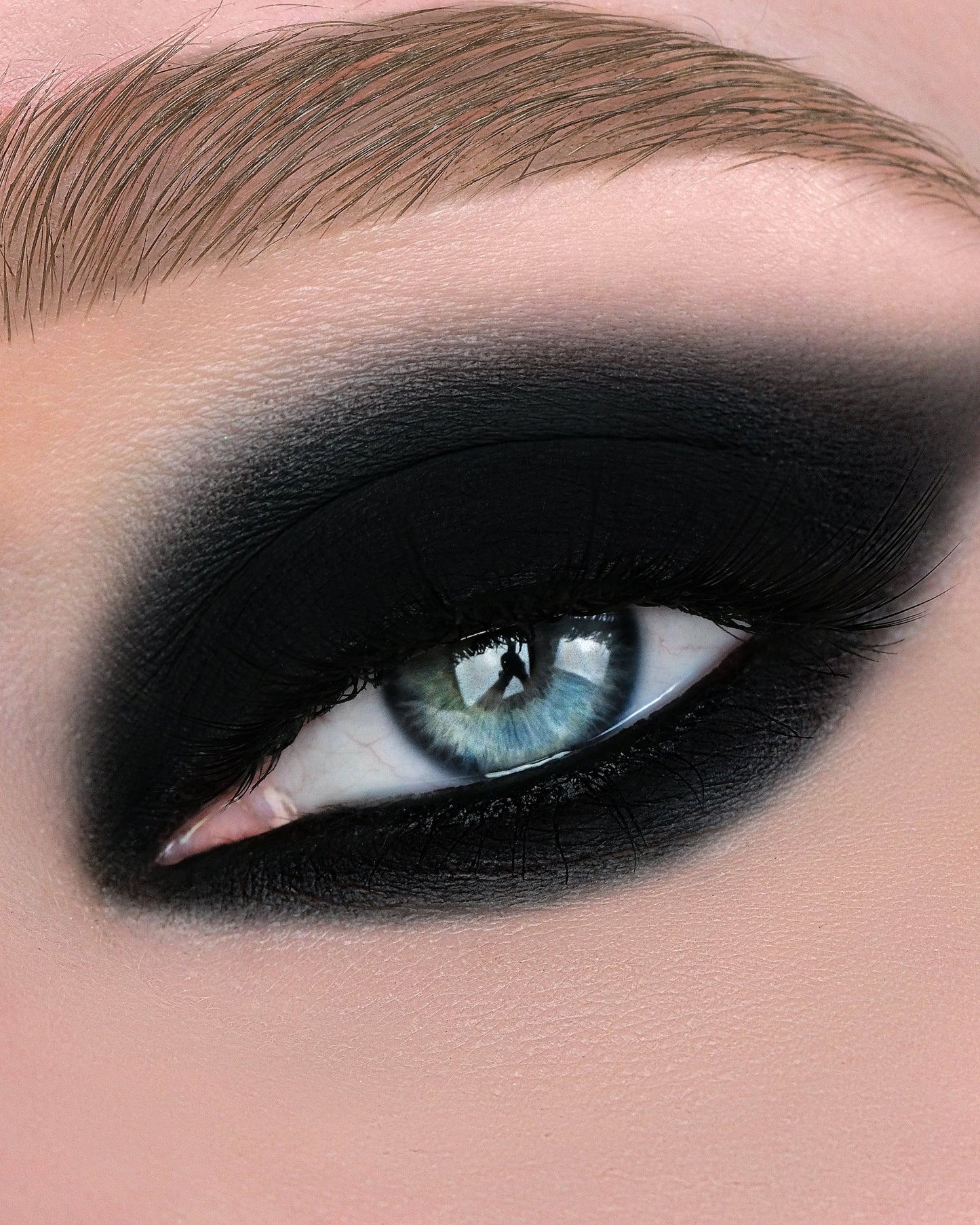 Close-up of an eye with dramatic makeup, including black eyeliner and smoky eye.