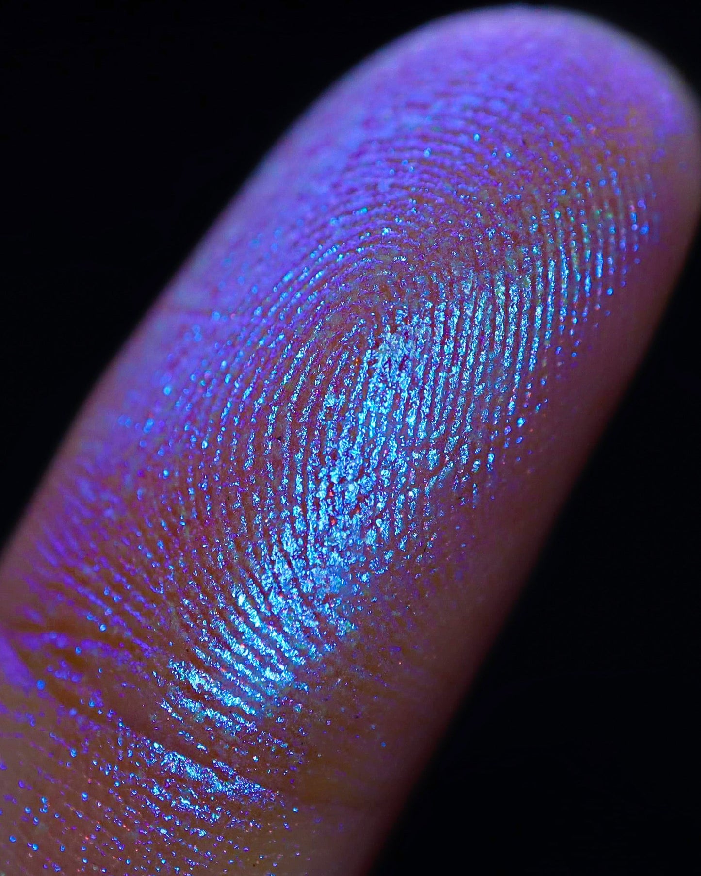 Close-up of a fingerprint under ultraviolet light with sparkly eyeshadow on it